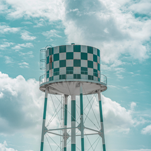 A green and white checkered water tower with rust