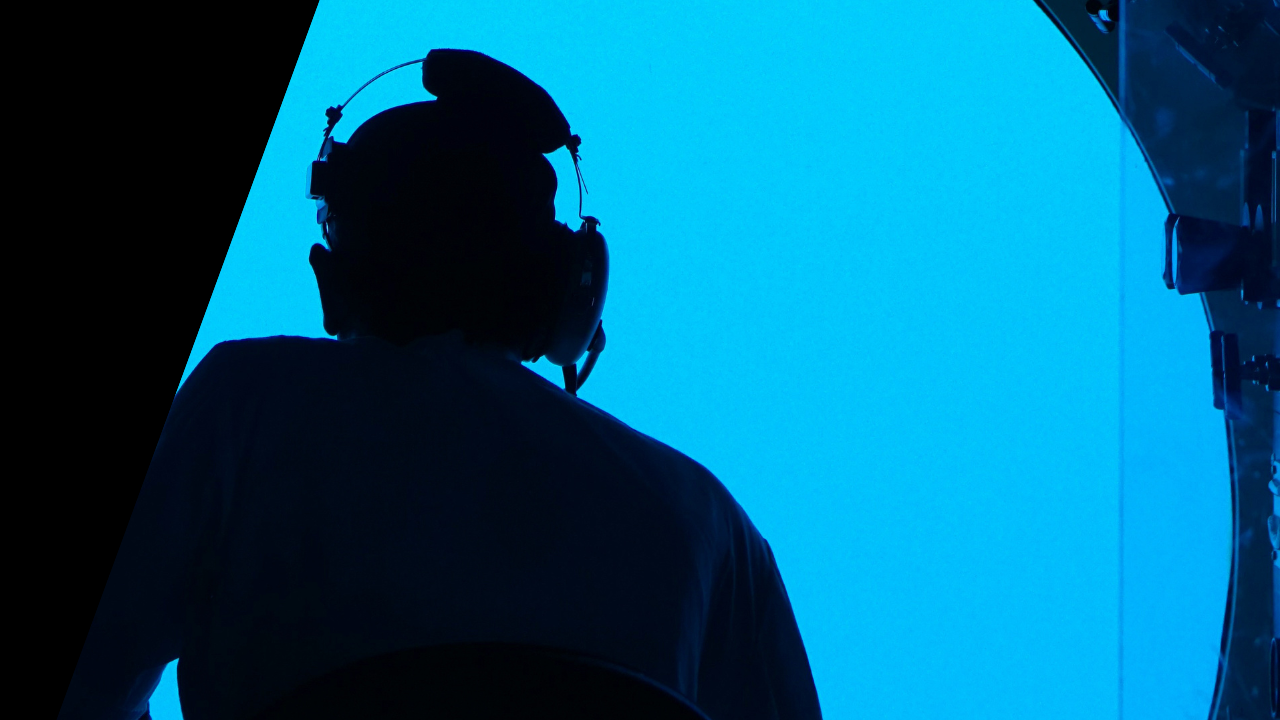 A man in a submarine with a blue background