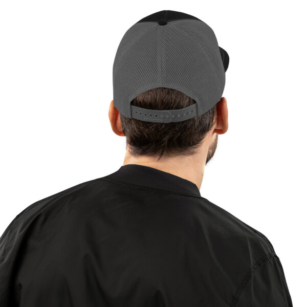 a man wearing a black bomber jacket and a grey hat