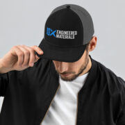 a man wearing a black and grey hat with the 10X Engineered Materials logo on it