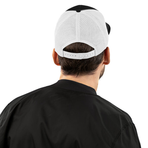 a man wearing a black jacket and a white and black hat