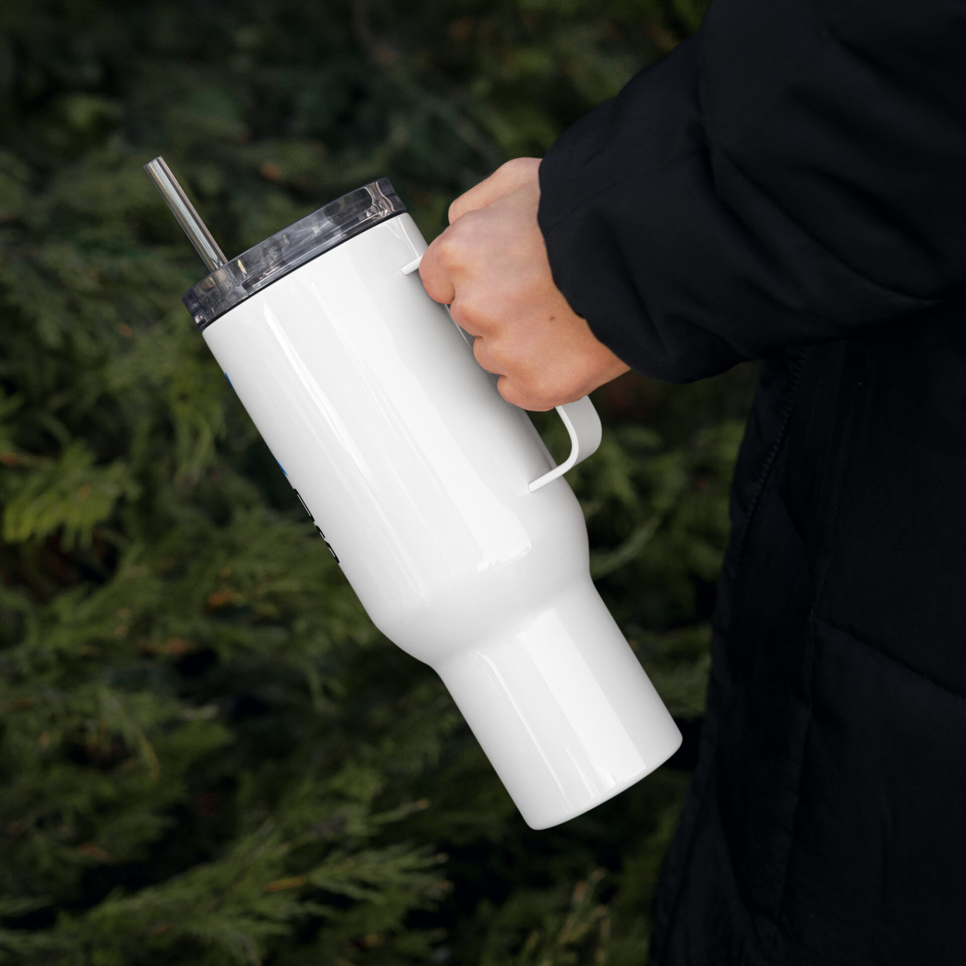 a person is holding a white tumbler with a straw