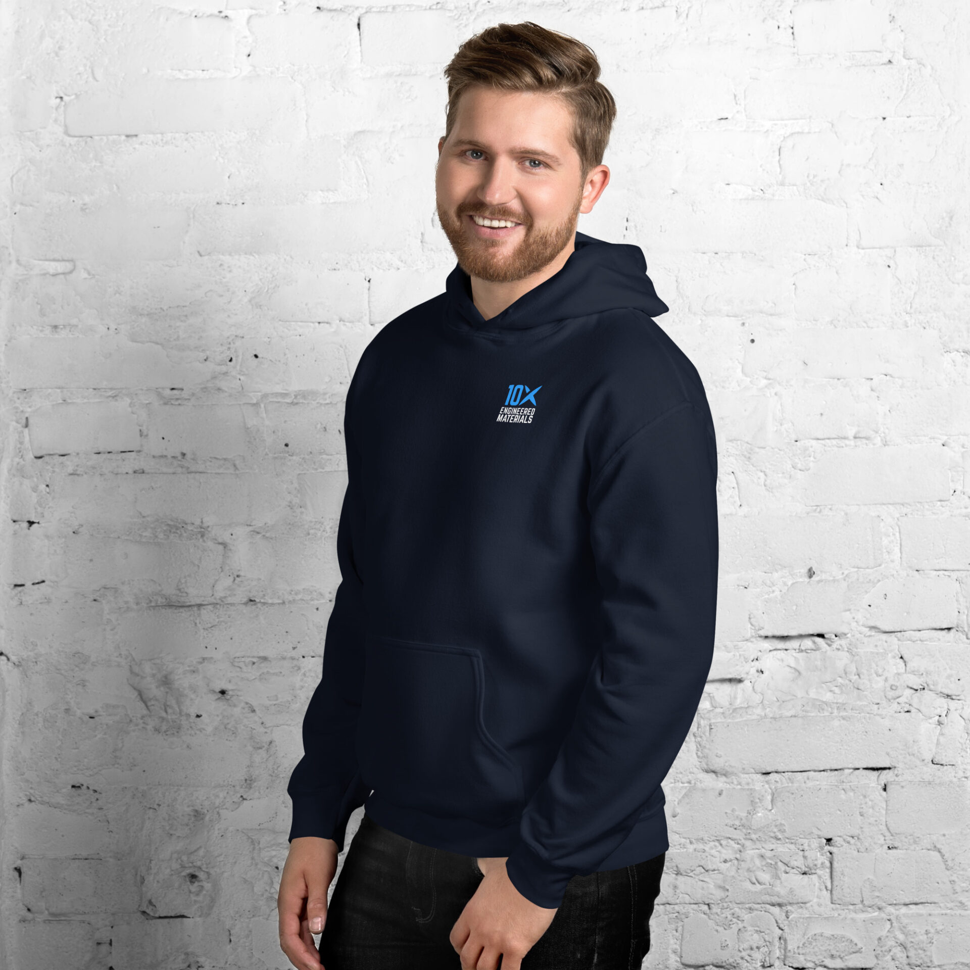 a man wearing a navy hoodie that has the 10X Engineered Materials logo on it