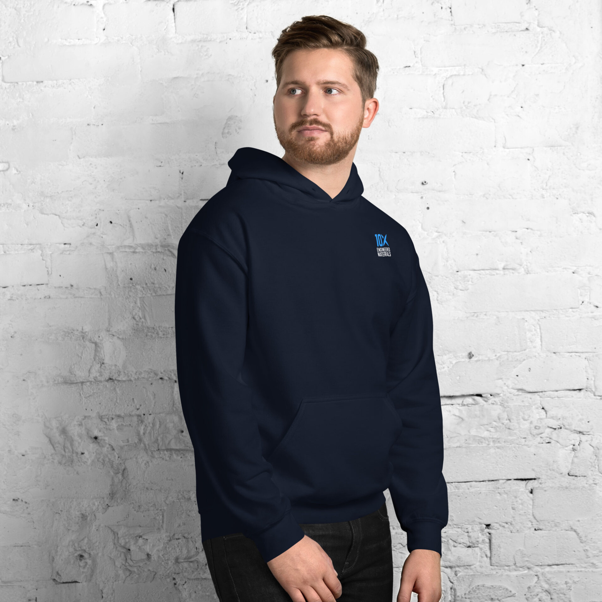 a man wearing a navy hoodie that has the 10X Engineered Materials logo on it